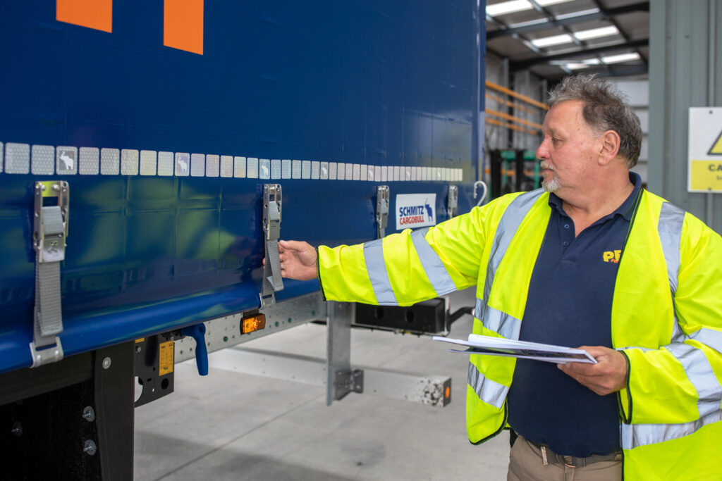 Driver inspects truck straps