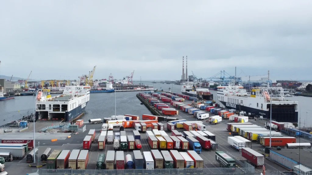 A wide view of Dublin Port featuring two ferries and a series of freight trailers